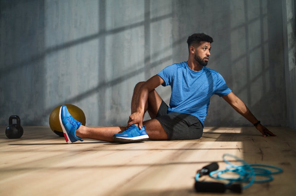 Man stretching after finishing a full body workout plan